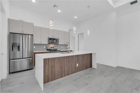 a kitchen with stainless steel appliances granite countertop a refrigerator and a stove