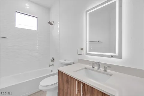 a bathroom with a granite countertop sink toilet a mirror and shower