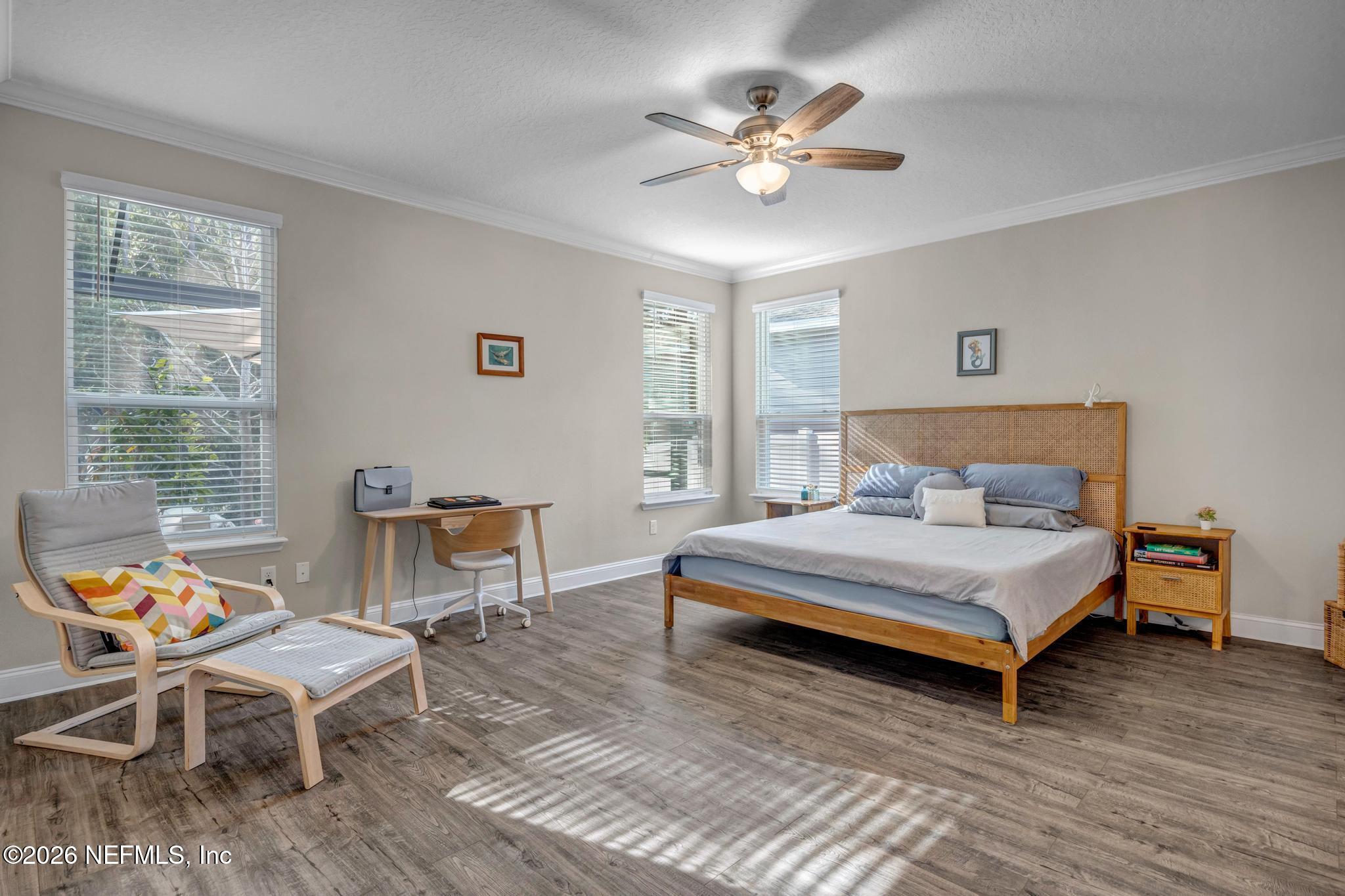 196 Silver Reef Lane St. Augustine, FL 32095 - Photo 23 of 62 a bedroom with a bed a chair and a chandelier