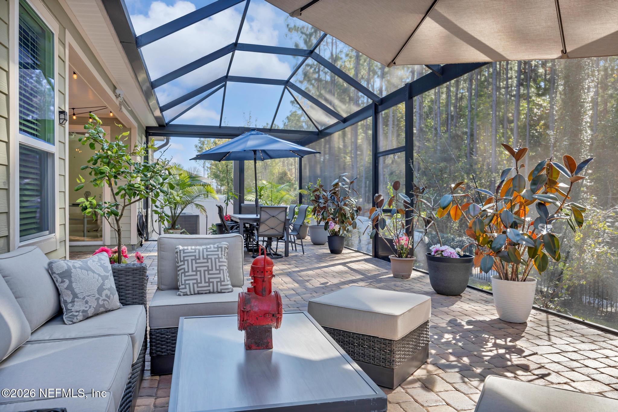 196 Silver Reef Lane St. Augustine, FL 32095 - Photo 34 of 62 a view of a patio with a dining table and chairs under an umbrella