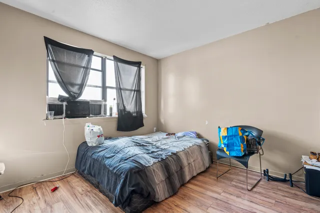 a bedroom with a bed a mirror and a window