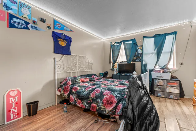 a bedroom with bed and wooden floor