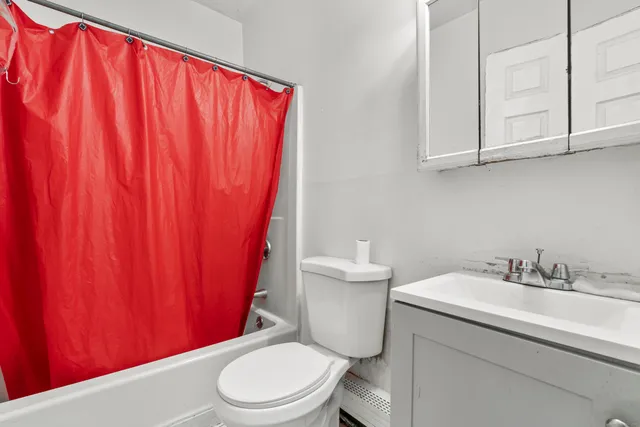 a bathroom with a toilet a sink and curtain