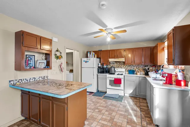 a open kitchen with stainless steel appliances granite countertop a sink dishwasher and a dining table with the kitchen view