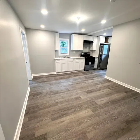 a view of a kitchen with a sink cabinets wooden floor and a window