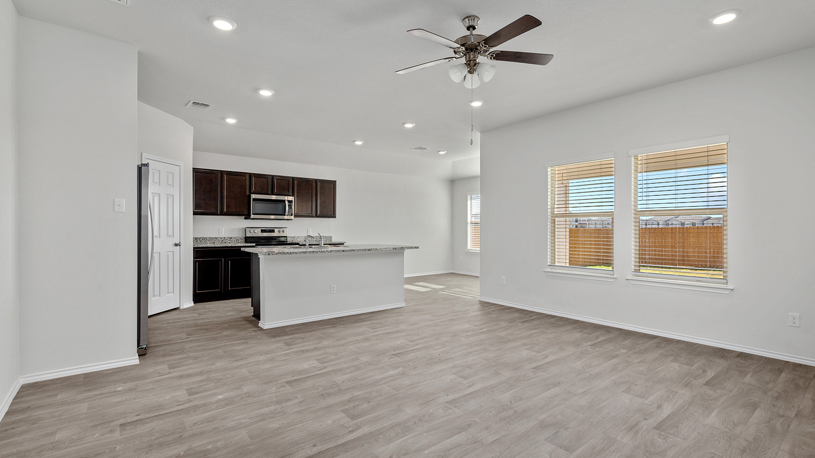 148 McNamara Court Jarrell, TX 76537 - Photo 22 of 22 Kitchen featuring dark wood finish cabinetry, an island with sink, a ceiling fan, recessed lighting, and open floor plan