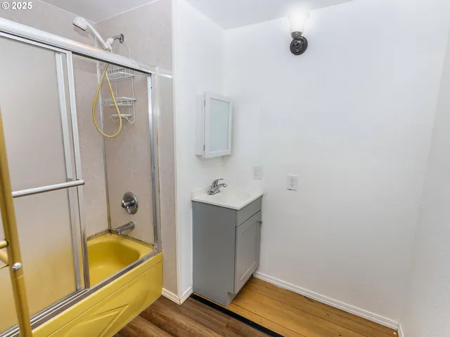 a bathroom with a tub sink and mirror