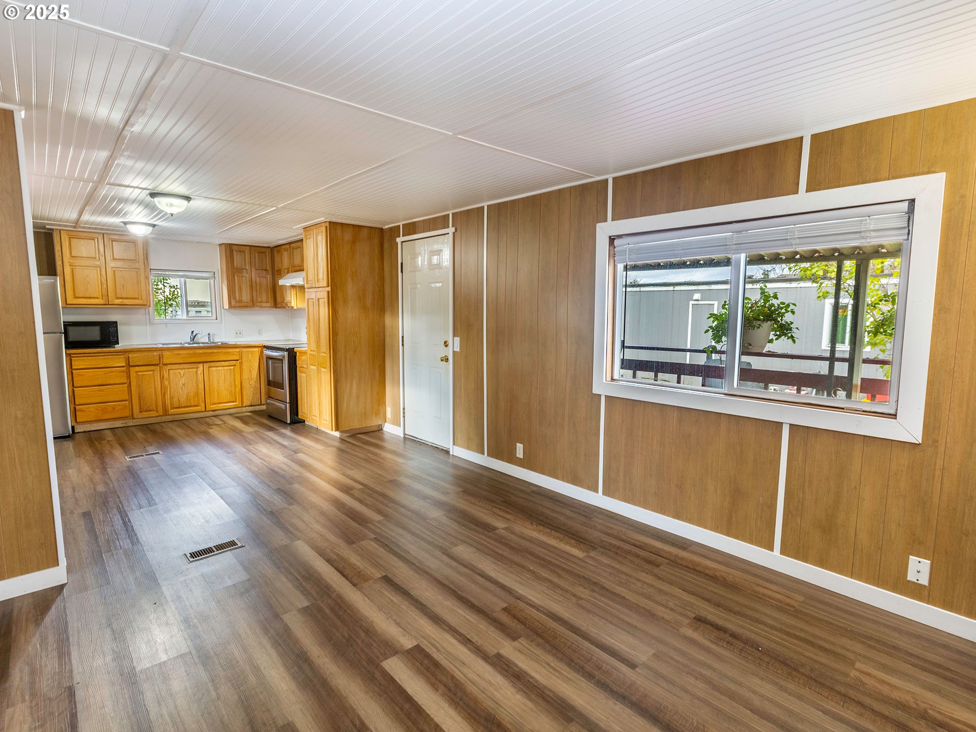 10701 Southeast Highway 212, Unit 13 Clackamas, OR 97015 - Photo 5 of 26 a view of a kitchen with wooden floor and a window