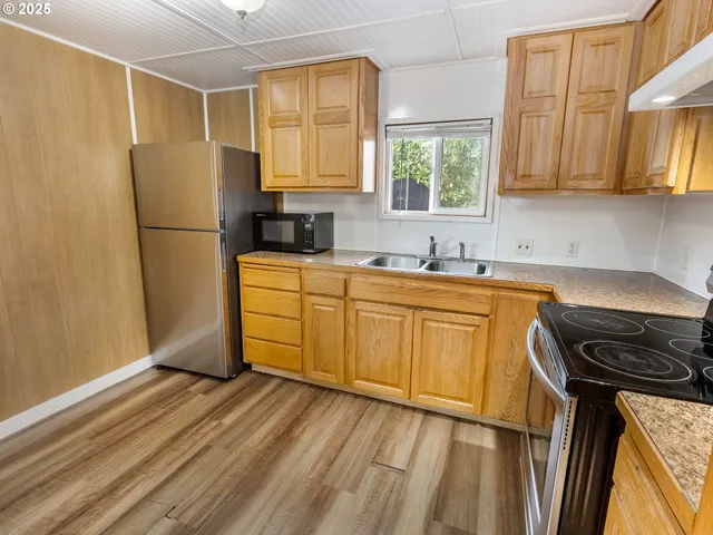 a kitchen with stainless steel appliances a refrigerator sink and cabinets