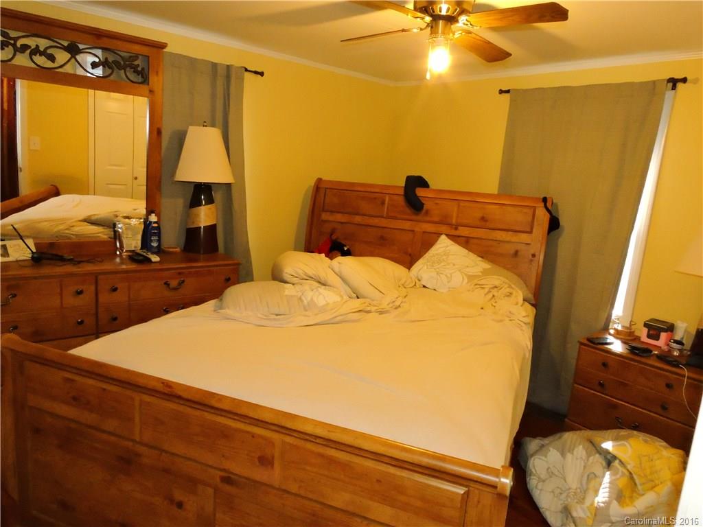 384 Scottdale Road Canton, NC 28716 - Photo 5 of 12 a bedroom with a bed and a chandelier