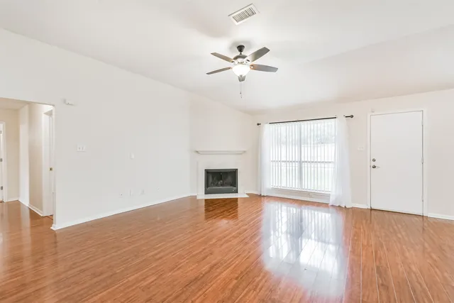 a view of empty room with wooden floor and fireplace