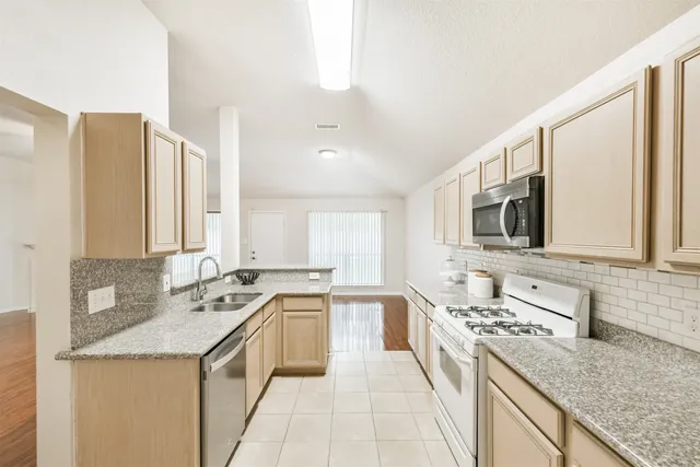 a large kitchen with a sink and cabinets