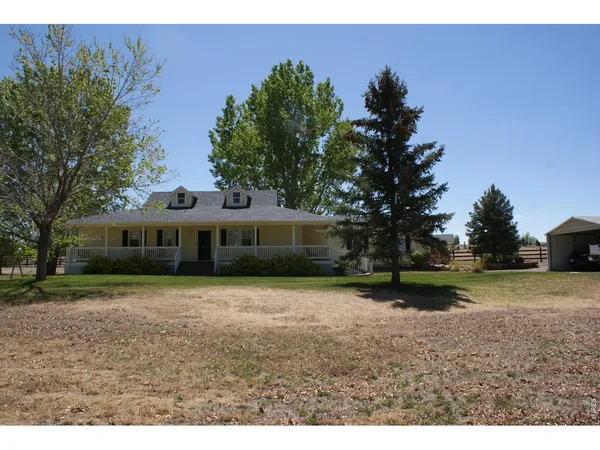 a front view of a house with a yard and trees