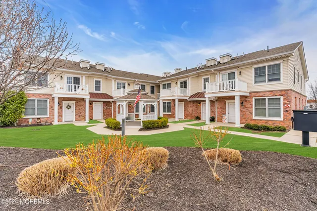 front view of a brick house with a yard