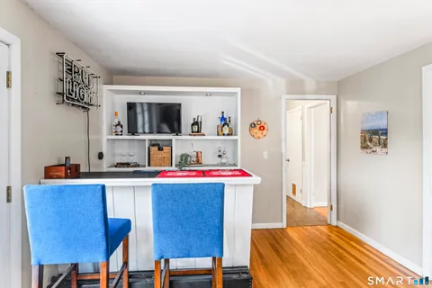 a living room with stainless steel appliances a dining table and chairs