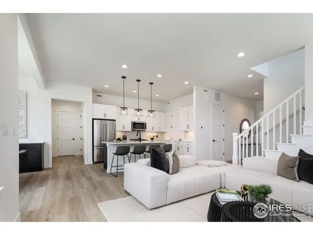 a living room with furniture and a dining table with kitchen view