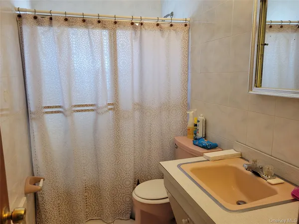 a bathroom with a sink a toilet and shower curtain