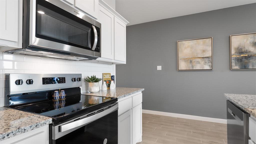 317 Potato Street Keene, TX 76059 - Photo 3 of 36 a kitchen with stainless steel appliances a stove microwave and sink