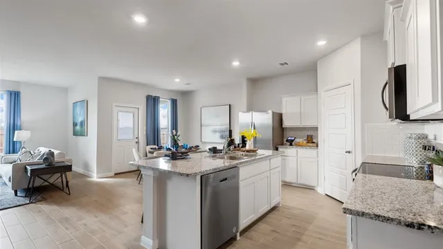 a kitchen with stainless steel appliances a stove microwave and sink