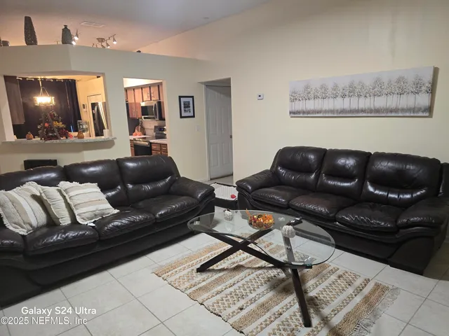 a living room with furniture and dresser with wooden floor