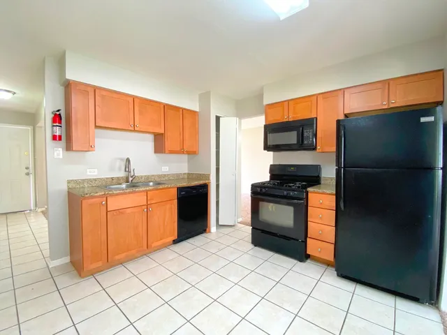 a kitchen with stainless steel appliances granite countertop a refrigerator and a sink
