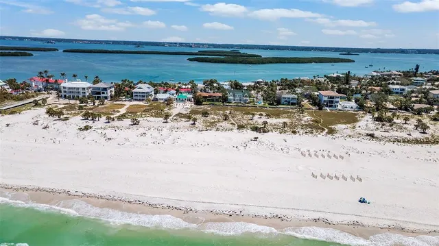an aerial view of a city with lots of residential buildings and ocean view in back