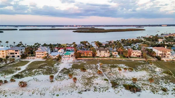 an aerial view of ocean and residential houses with outdoor space