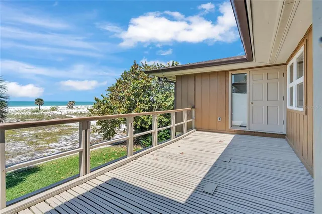 a view of a balcony with wooden floor & fence