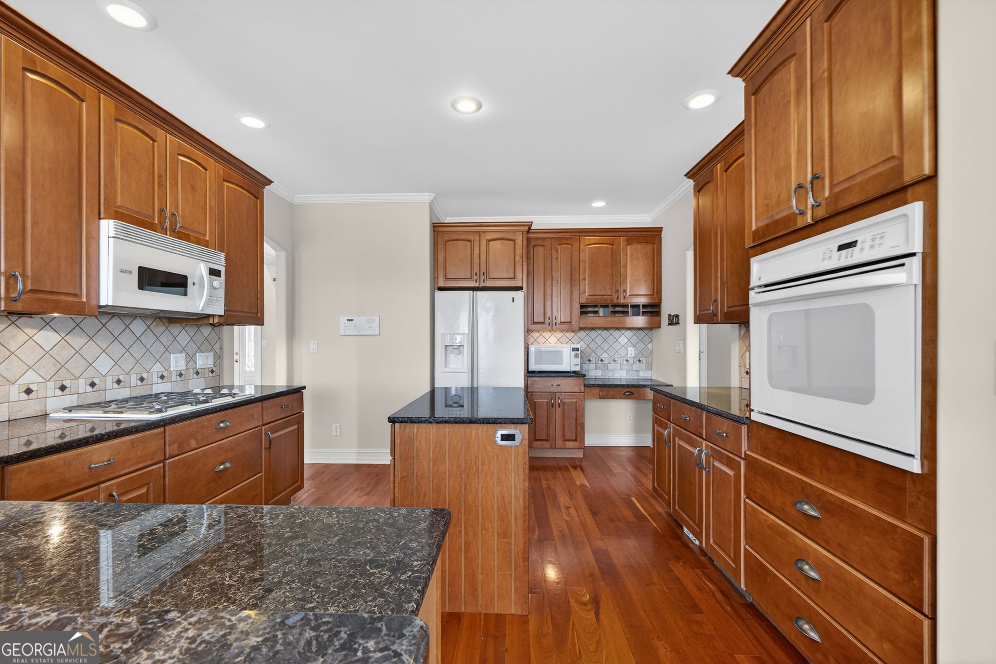 357 Canvasback Trail Locust Grove, GA 30248 - Photo 6 of 35 a large kitchen with stainless steel appliances granite countertop a stove a sink and a microwave