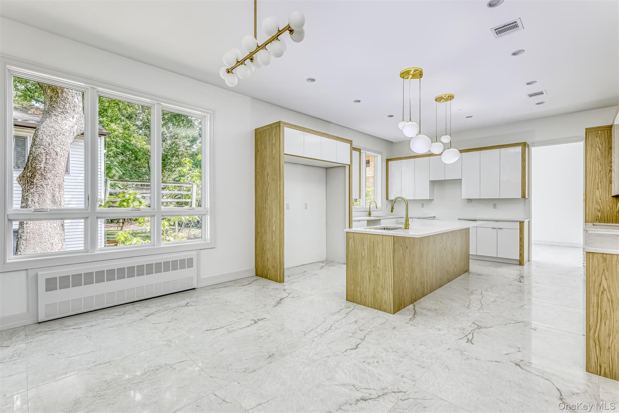 128 Union Road, Unit 201 Spring Valley, NY 10977 - Photo 12 of 48 Kitchen featuring white cabinets, radiator, an island with sink, decorative light fixtures, and recessed lighting