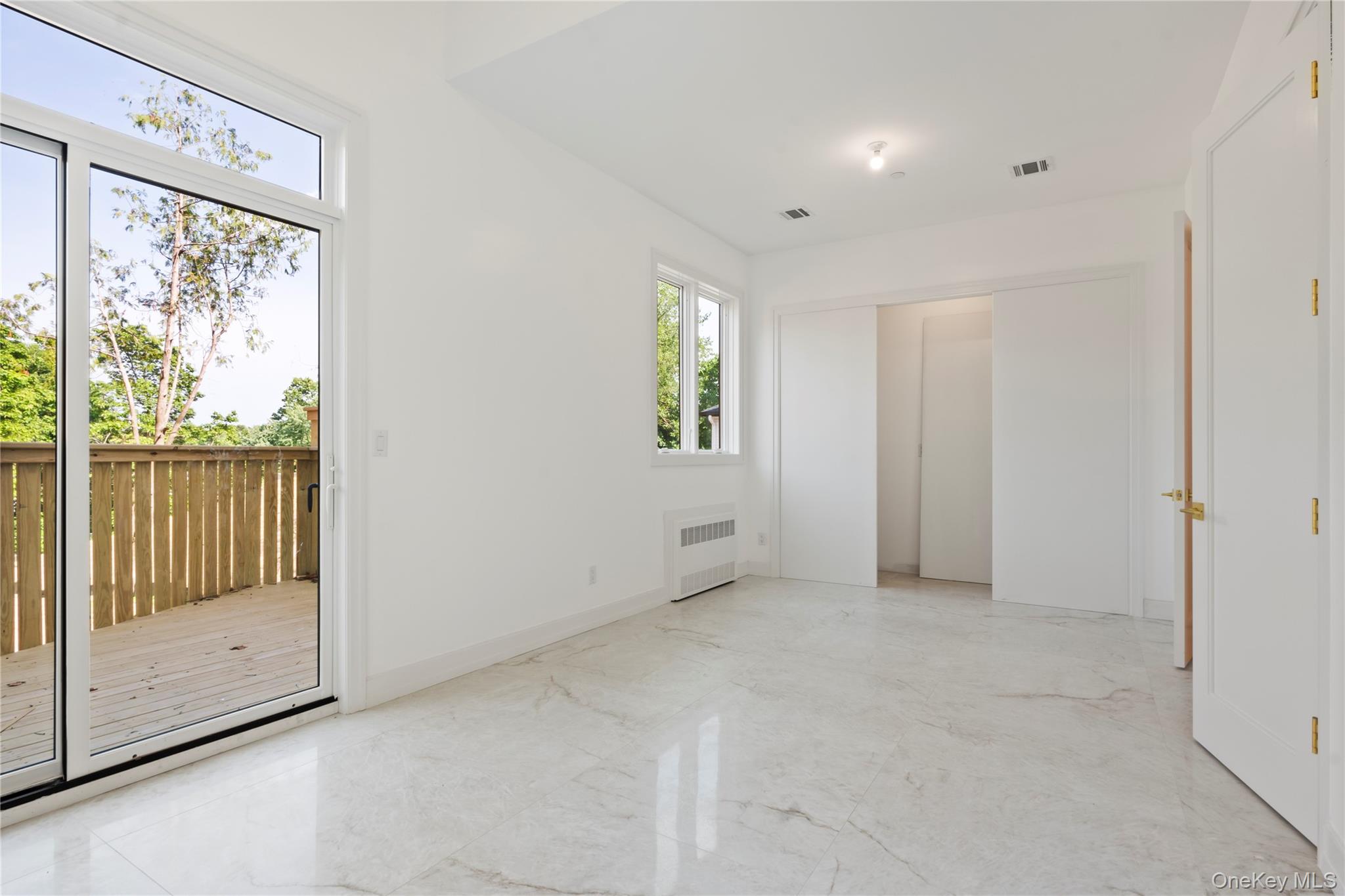 128 Union Road, Unit 201 Spring Valley, NY 10977 - Photo 18 of 48 Unfurnished bedroom featuring light marble finish floors, radiator heating unit, and access to outside