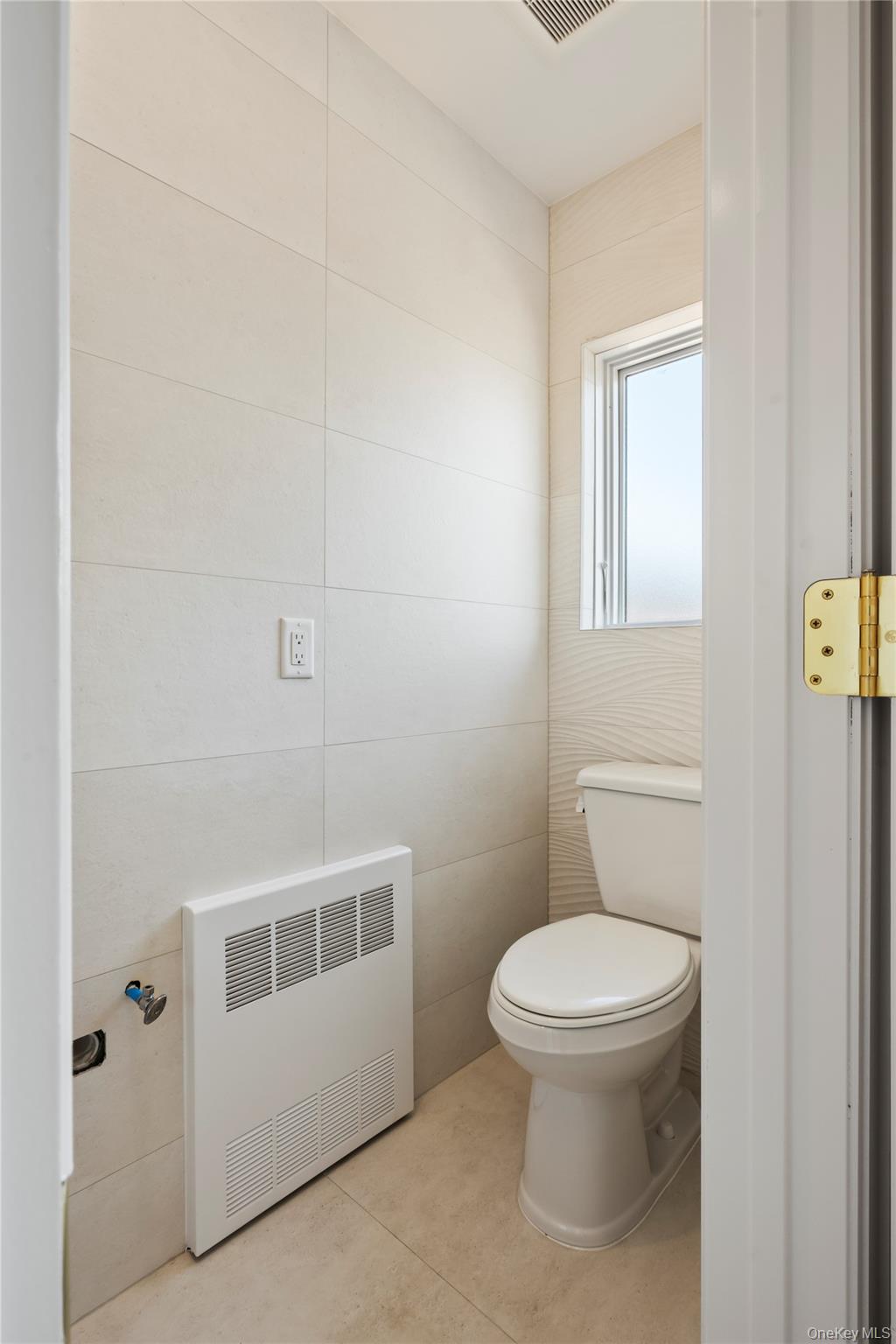 128 Union Road, Unit 201 Spring Valley, NY 10977 - Photo 36 of 48 Bathroom featuring light tile patterned floors, tile walls, and heating unit