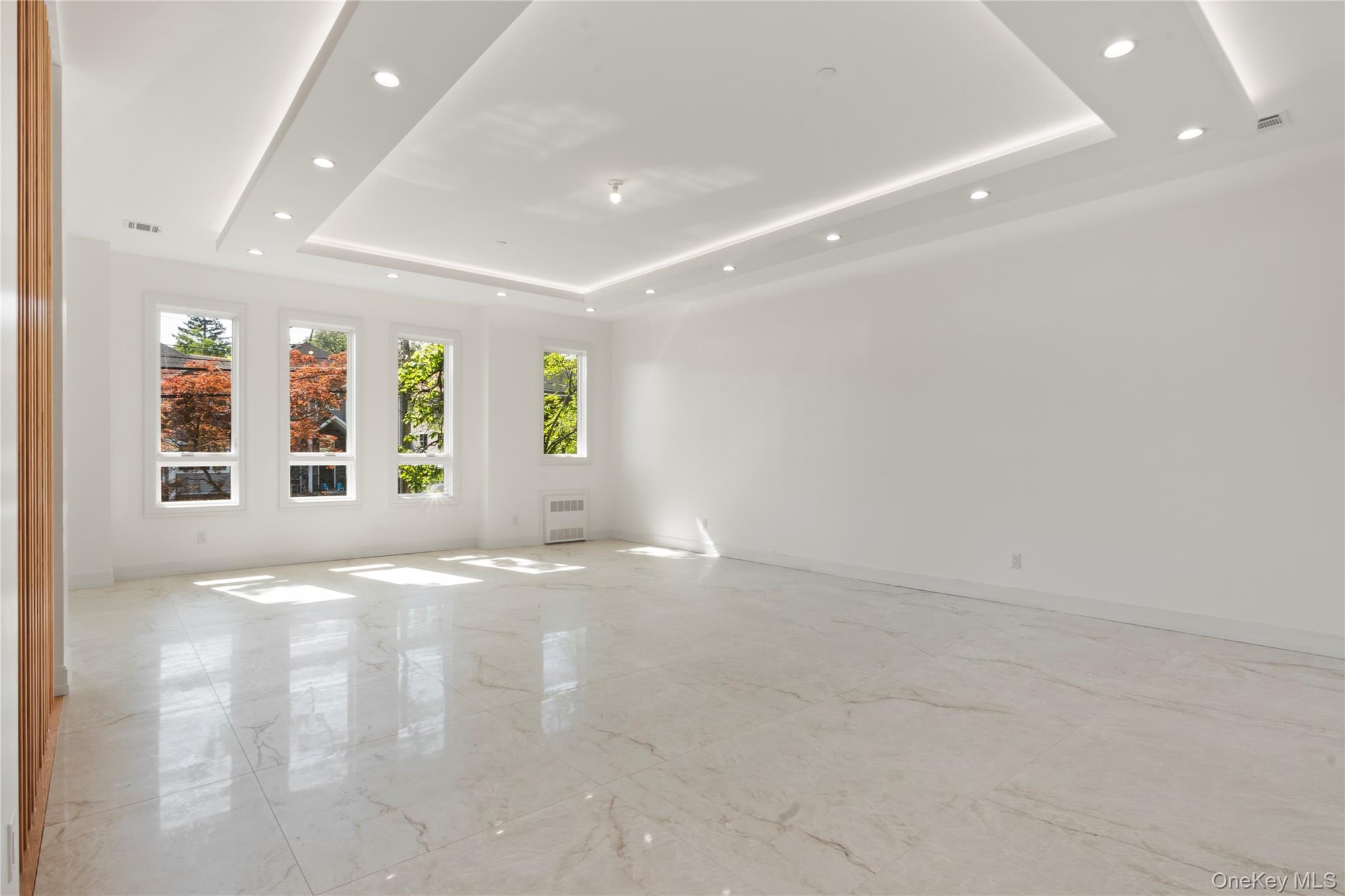 128 Union Road, Unit 201 Spring Valley, NY 10977 - Photo 8 of 48 Spare room with light marble finish floors, a tray ceiling, recessed lighting, and radiator