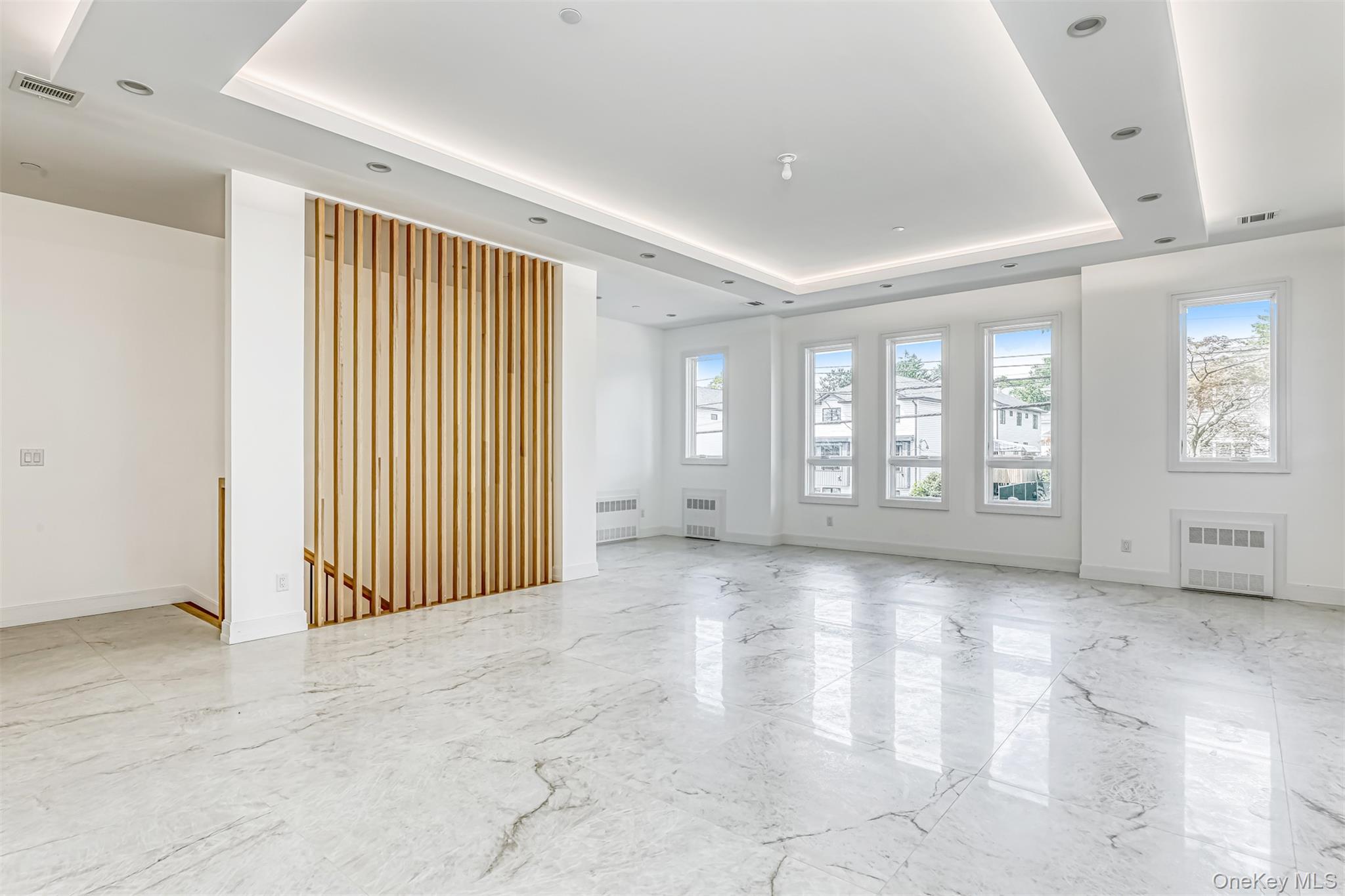 128 Union Road, Unit 201 Spring Valley, NY 10977 - Photo 10 of 48 Empty room with a tray ceiling, light marble finish flooring, and radiator heating unit