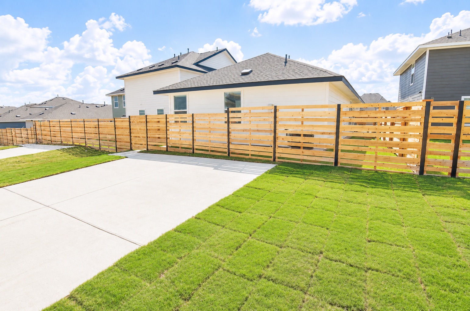 397 Keefer Kyle, TX 78640 - Photo 31 of 33 A newly installed wooden privacy fence encloses a backyard with fresh sod and a concrete path.