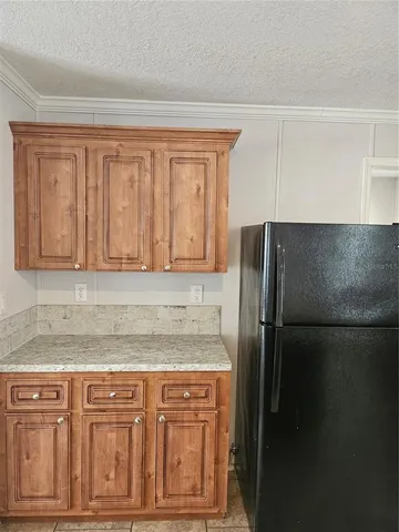 a kitchen with granite countertop cabinets and refrigerator