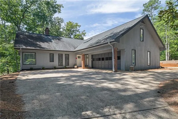 a view of a house with a backyard and trees