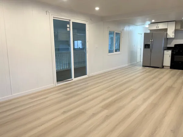 a view of empty room with a kitchen
