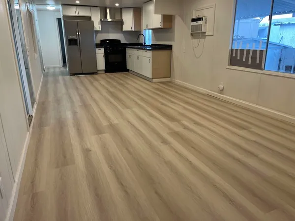 a kitchen with a refrigerator sink and wooden floor