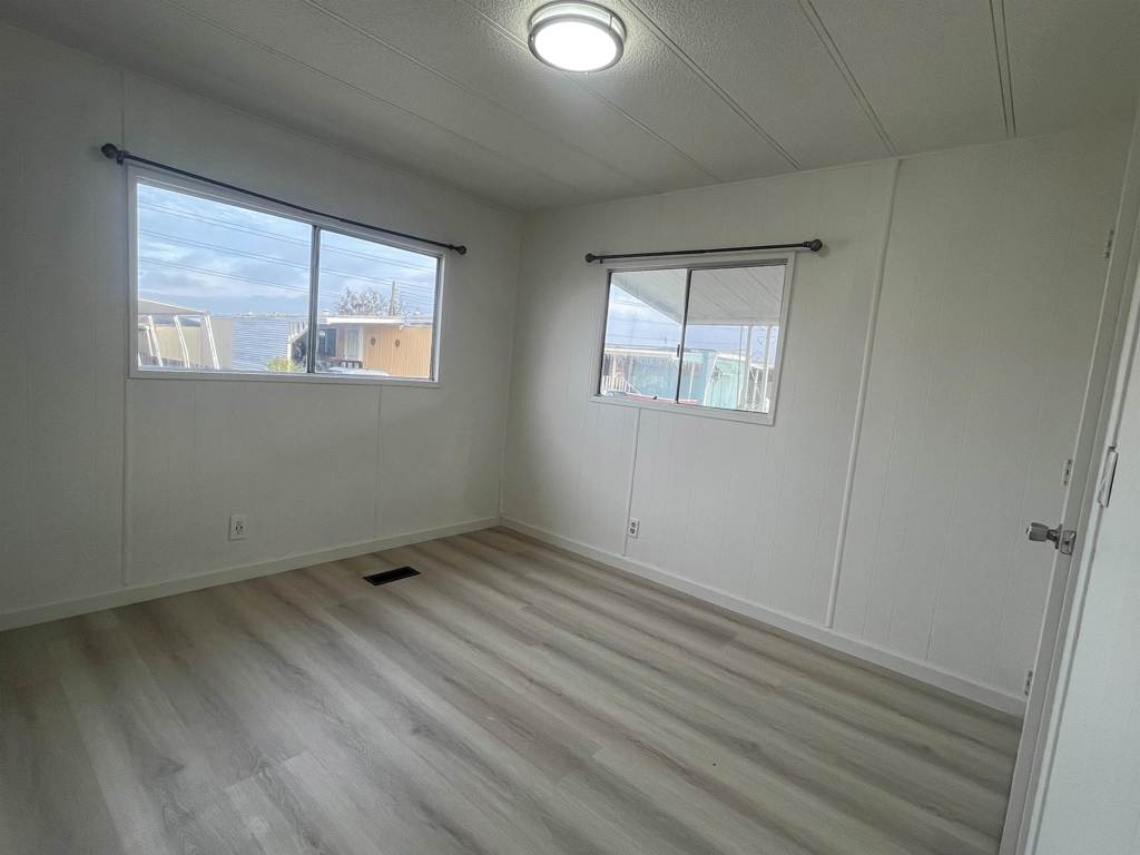 4143 Yosemite Boulevard Modesto, CA 95357 - Photo 17 of 22 an empty room with wooden floor and windows