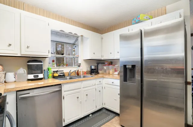a kitchen with a refrigerator sink and cabinets