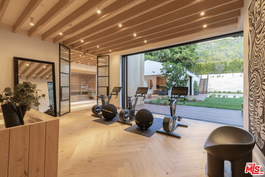 16036 Woodvale Road Encino, CA 91436 - Photo 17 of 54 a room with gym equipment and a large window