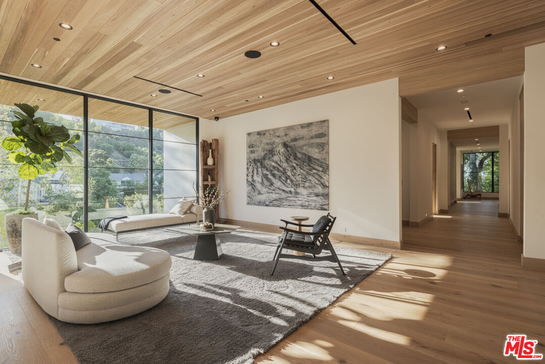 16036 Woodvale Road Encino, CA 91436 - Photo 25 of 54 a living room with furniture and large windows