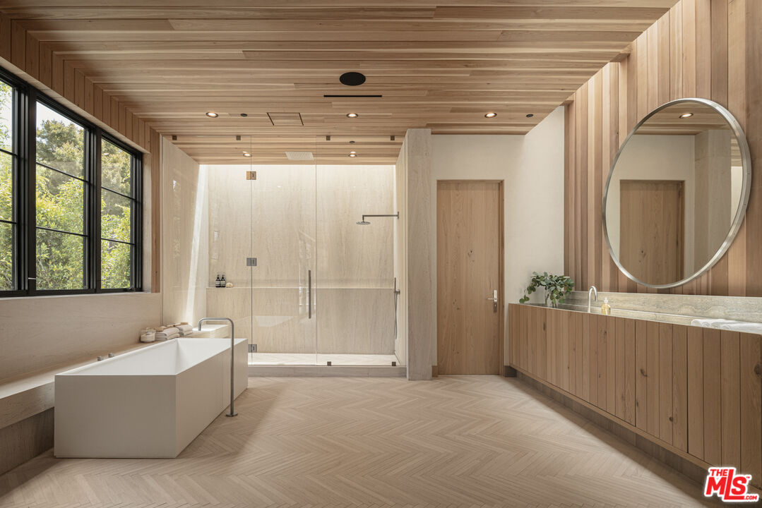 16036 Woodvale Road Encino, CA 91436 - Photo 28 of 54 a bathroom with a tub a sink and mirror