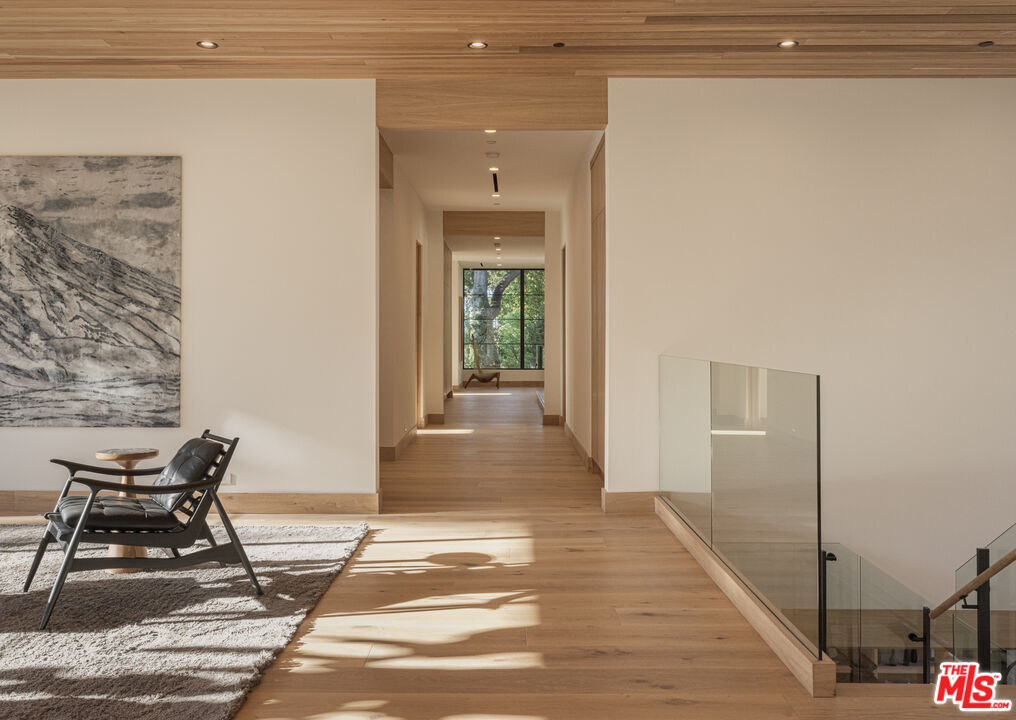16036 Woodvale Road Encino, CA 91436 - Photo 33 of 54 a view of a hallway with wooden floor and chair