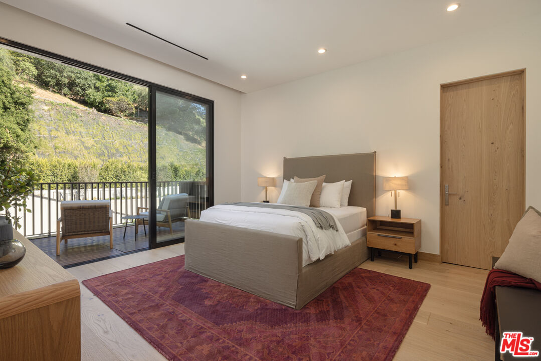 16036 Woodvale Road Encino, CA 91436 - Photo 34 of 54 a spacious bedroom with a large bed and a large window