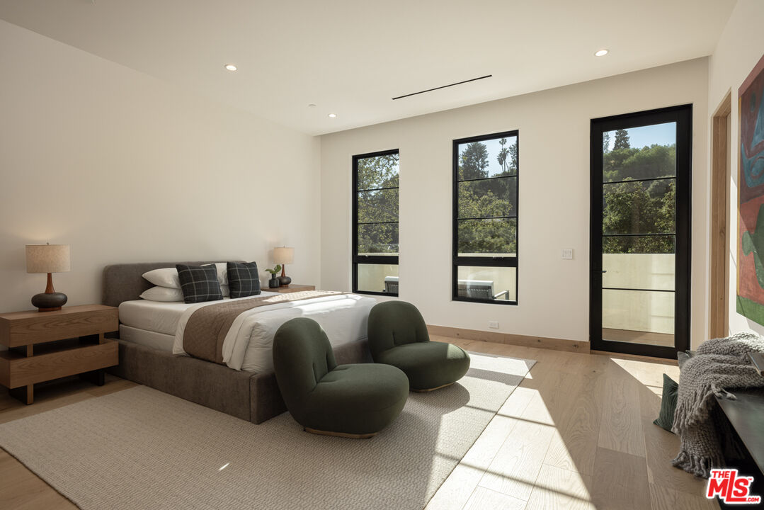 16036 Woodvale Road Encino, CA 91436 - Photo 36 of 54 a spacious bedroom with a bed and glass window