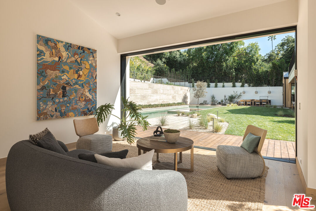 16036 Woodvale Road Encino, CA 91436 - Photo 44 of 54 a dining room with furniture and a floor to ceiling window