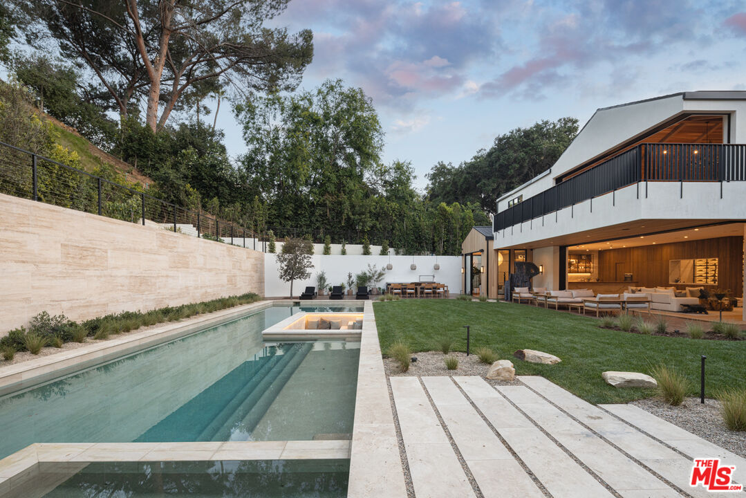 16036 Woodvale Road Encino, CA 91436 - Photo 47 of 54 a view of a patio with lawn chairs floor to ceiling window next to a yard