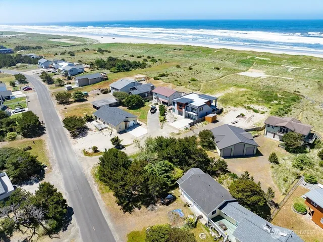 an aerial view of ocean and residential houses with outdoor space